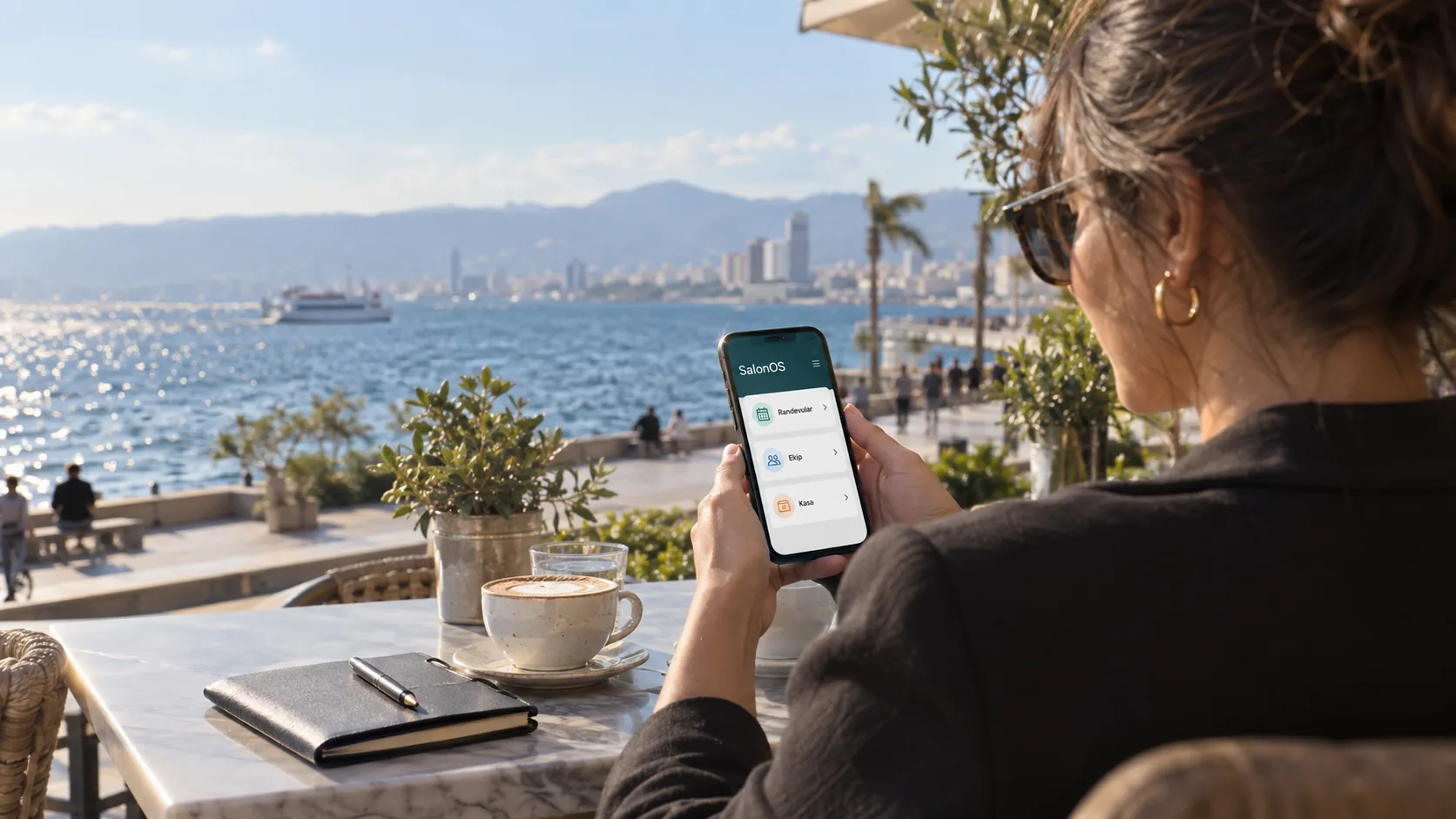 Salon sahibi dışarıda otururken telefonundaki SalonOS yönetim görünümünü doğal bir tutuşla kontrol ediyor